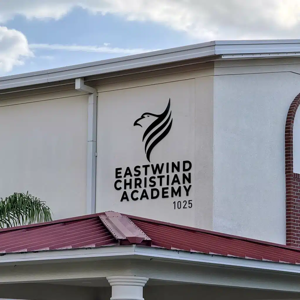 Eastwind Christian Academy wall sign featuring the academy's logo and address.